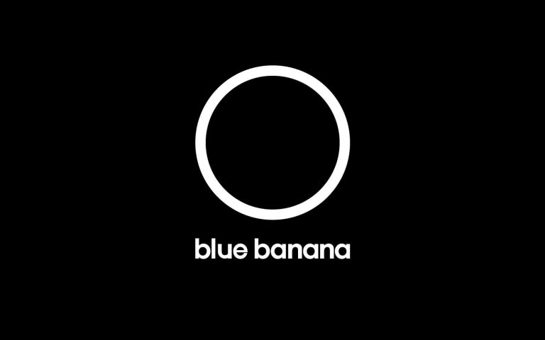 Logotipo minimalista de Blue Banana: un círculo blanco sobre fondo negro con la marca “blue banana” en tipografía moderna, simbolizando su nueva identidad y rebranding.